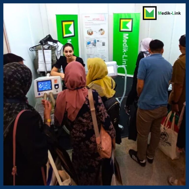Event attendees exploring Medik-Link’s booth featuring Philips EV300 respiratory and monitoring equipment and Lifotronic HFCWO Airway Clearance Equipment